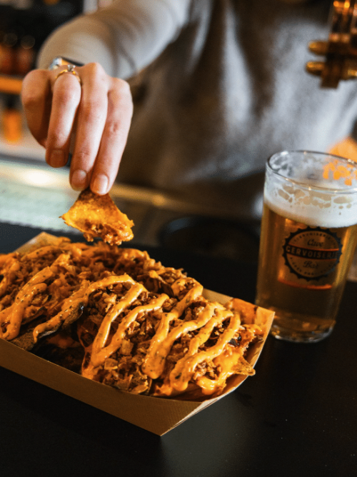 BIÈRE POSÉE À CÔTÉ D'UNE PLANCHE APÉRO AU BAR À BIÈRE LA CERVOISERIE COGNAC