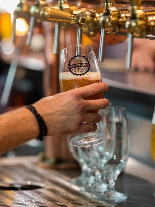 PESONNE QUI SERT UNE BIÈRE À LA CERVOISERIE